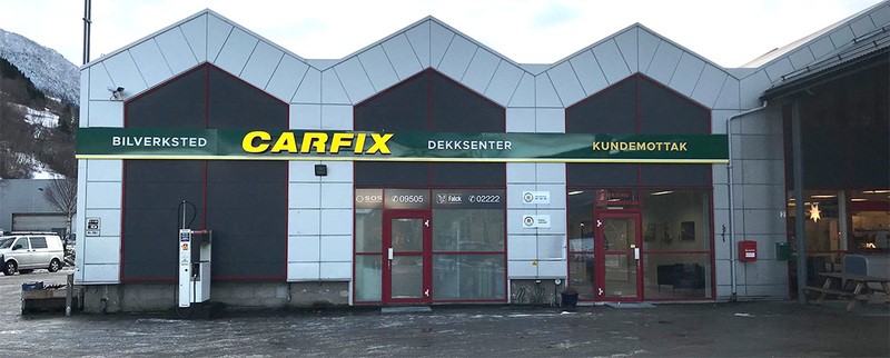 Bilde av utsiden av Carfix Vik, med Carfix-profilering. Inngangen til kundemottaket ligger til høyre i bilde. Utsiden er asfaltert.